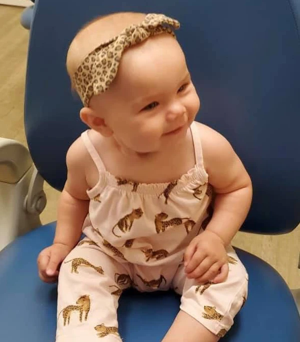 An infant sitting in a chair smiling